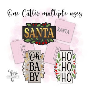 May include: A cookie cutter with multiple uses. The cutter is shaped like a rectangle with a wreath of leaves and berries around the edges. The cutter can be used to make cookies with the words "Santa", "Oh Baby", and "Ho Ho Ho".
