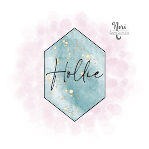 May include: A teal blue hexagon with gold glitter accents and the word "Hollie" written in black cursive. The hexagon is on a pink watercolor background with white dots.