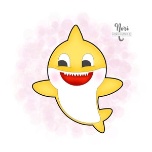 May include: A yellow cartoon shark cookie cutter with a big smile and white belly. The cookie cutter is on a pink watercolor background. The text "Nori Cookie Cutters by" is in the top right corner of the image.