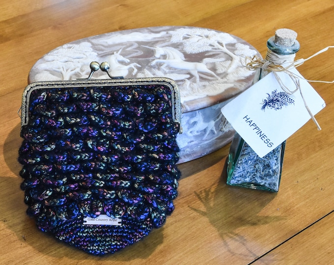 Small hand crocheted evening purse. Metallic colored yarn in a black background. 6" wide X 7.25" tall. Hand made one of a kind.