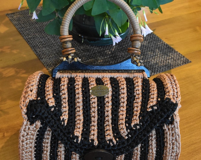 Hand crocheted barrel purse, one of a kind. Black and Gold crochet with carved wooden ends. 10" wide, 12" tall, 6" diameter.