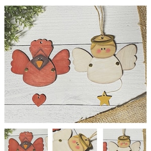 May include: Two wooden ornaments, one a red cardinal with wings and a heart, the other a white angel with wings and a star.