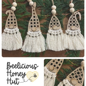 Könnte beinhalten: Vier hölzerne Gnom-Ornamente mit einem Wabenmuster und weißen Garnquasten. Die Gnome hängen an einem grünen Kiefernzweig. Der Text "Beelicious Honey Hut" befindet sich in der linken unteren Ecke des Bildes.