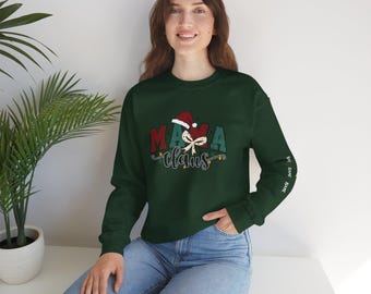 May include: A dark green sweatshirt with the text "Mama Claus" in red and green, with a Santa hat and bow graphic. The sleeve has the text "NAME" repeated. The sweatshirt is a festive holiday apparel item.