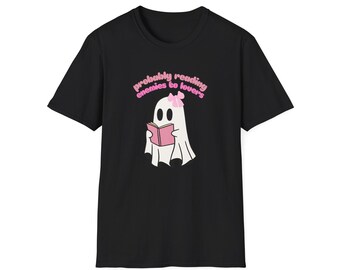 May include: Black t-shirt featuring a cartoon ghost reading a pink book. The ghost has a pink bow and the text "probably reading enemies to lovers" in pink above it. The shirt is a crew neck.
