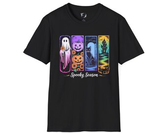 May include: Black t-shirt featuring a colorful "Spooky Season" graphic. The design includes a ghost, pumpkins, a black cat, and a haunted house. The graphic is in a vertical rectangular format.