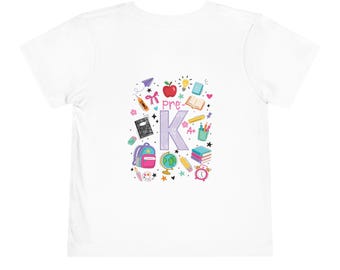 May include: A white short-sleeved t-shirt featuring a central graphic with the text pre-K in large purple letters. The design includes colorful illustrations of a red apple, a globe, a pink backpack, books, pencils, a clock, and school supplies.