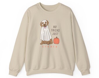 May include: Beige sweatshirt with a Halloween-themed graphic. The design features a dog dressed as a ghost, a pumpkin, and the text "NO TRICKS JUST treats" in a playful font. A cozy and festive apparel item.