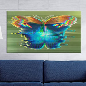 May include: A canvas print featuring a digital art butterfly with a glitch effect. The butterfly has blue, orange, and yellow wings against a green background. The artwork is displayed above a blue sofa.