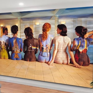 Puede incluir: Una impresión en lienzo que presenta a un grupo de seis personas pintadas con imágenes de portadas de álbumes famosos. Las personas están sentadas en una fila, de cara al espectador, con la espalda a la cámara. Las portadas de los álbumes incluyen "Dark Side of the Moon", "The Wall", "Wish You Were Here", "Animals", "The Division Bell" y "Ummagumma".