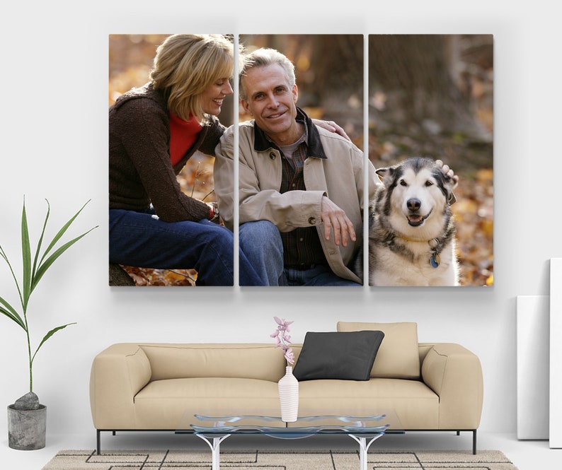 May include: A three-panel canvas print depicting a couple and a dog in a natural setting. The couple are seated, smiling, and interacting with a large dog. The background features autumn leaves, creating a warm, natural scene.
