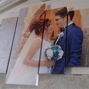 May include: A multi-panel canvas print depicting a wedding scene. The image shows a bride in a white dress with a bouquet and a groom in a blue suit. The print is displayed on a light surface.