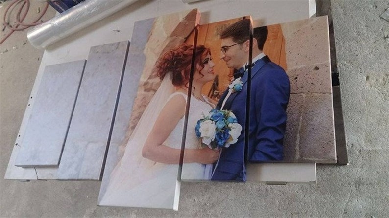 May include: A multi-panel canvas print depicting a wedding scene. The image shows a bride in a white dress with a bouquet and a groom in a blue suit. The print is displayed on a light surface.