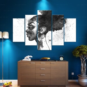May include: A five-panel black and white artwork depicting a woman's profile. The artwork features a watercolor style with splatters and a dark background. The woman is wearing large hoop earrings. The artwork is displayed on a blue wall above a wooden cabinet.