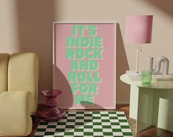 May include: A pink and green poster with the text "It's Indie Rock and Roll for Me" hanging on a wall above a green checkered rug. A yellow couch is in the foreground, and a pink lamp with a green glass is on a green table.