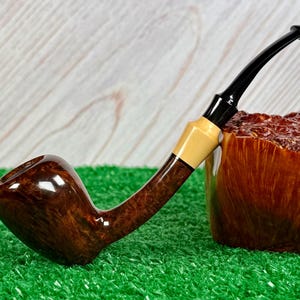 May include: A white ceramic mug with a black handle and the text "But First, Coffee" in a black, bold font. The mug is on a white surface.