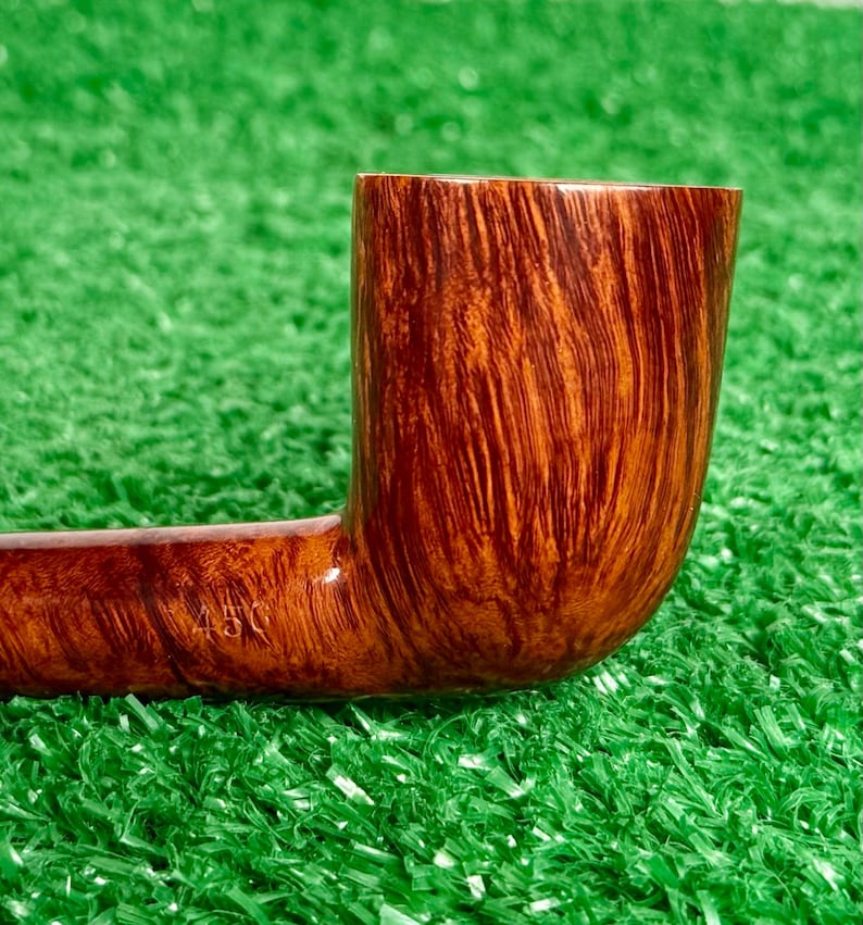 May include: A polished brown wooden tobacco pipe with a smooth, vertical grain pattern. The side of the pipe features the stamped text 450, indicating a specific model or production number on the curved shank near the bowl.