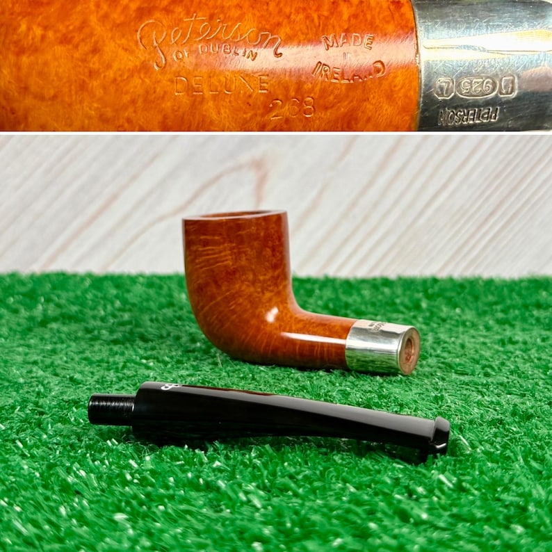 Puede incluir: Una pipa de tabaco de madera marr&oacute;n con una banda de plata y una boquilla negra desmontable. La pipa tiene grabado el texto Peterson of Dublin, Deluxe, 268 y Made in Ireland. La banda de plata muestra el sello 925 y la marca Peterson.