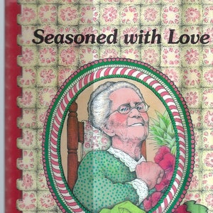 May include: A vintage cookbook titled "Seasoned with Love" featuring a colorful illustration of an older woman holding a bouquet of flowers. The cover has a red background with a floral pattern and the text "Apache Junction Health Center" at the bottom.