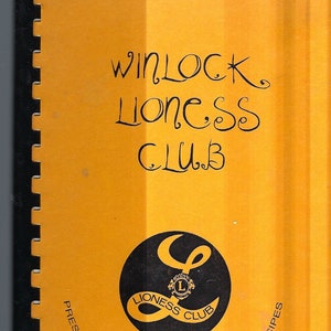 May include: A yellow cookbook with the title "Winlock Lioness Club Presents a Collection of Favorite Recipes" and a black and white logo of a lioness with the words "Lioness Club".