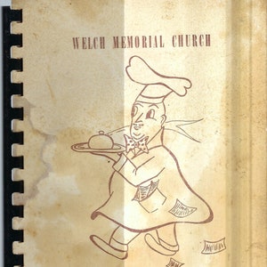Könnte beinhalten: Ein altes Kochbuch mit braunem Einband und einer Comic-Illustration eines Kochs, der eine Platte mit Essen trägt. Der Text auf dem Einband lautet "Welch Memorial Church Woman's Society of Christian Service".