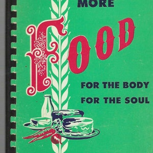 May include: A green cookbook with the title "More Food For The Body For The Soul" in black text. The cover features a stylized red "Food" with a white wheat stalk and a still life of food items.