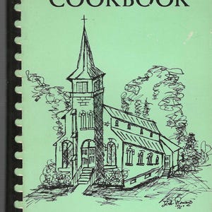 May include: A vintage cookbook cover from the 1975 edition. The cover is light green with black text and a line drawing of a church. The title reads "COOKBOOK" and "Favorite Recipes From Ladies of St. John's Starlight."