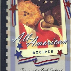 May include: A cookbook titled "All-American Recipes" with a red, white, and blue theme. The cover features a pie, baseball, and a baseball bat. The book is from Sequoyah High School's AFJROTC.