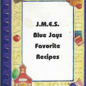 Puede incluir: Un libro de recetas encuadernado en espiral con una cubierta azul y un interior blanco. La portada presenta el texto "J.M.E.S. Blue Jays Favorite Recipes" e ilustraciones de manzanas, una escuela y una bandera estadounidense. El libro tiene un borde amarillo con el alfabeto.