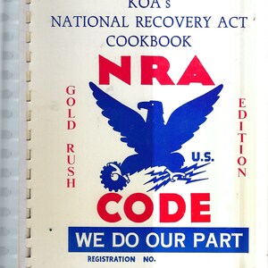 Könnte beinhalten: Ein weißes Kochbuch mit dem Titel "KOA'S NATIONAL RECOVERY ACT COOKBOOK" und dem Text "NRA GOLD RUSH EDITION" und "U.S. CODE WE DO OUR PART" in Rot und Blau. Das Cover zeigt einen blauen Adler mit einem rot-weiß-blauen Zahnrad.