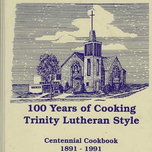 May include: A vintage cookbook cover with a blue and white illustration of a church, a tree, and clouds. The title reads "100 Years of Cooking Trinity Lutheran Style." Below, it says "Centennial Cookbook 1891 - 1991."
