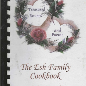 May include: A cookbook titled "The Esh Family Cookbook" with the subtitle "The Humps." The cover features a heart-shaped floral design with the words "Treasured Recipes and Poems."