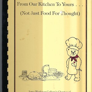 May include: A yellow cookbook with the title "From Our Kitchen To Yours... (Not Just Food For Thought)" and a cartoon illustration of a teddy bear chef. The book is published by the Iowa Wesleyan College's Chapter of Phi Beta Lambda, Business Fraternity.