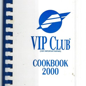 Puede incluir: Un libro de cocina blanco con un logotipo azul de un círculo con un avión blanco en su interior. El texto "VIP CLUB (VERY IMPORTANT PARTNER) COOKBOOK 2000" está impreso en azul.