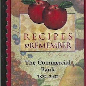 May include: A red cookbook with a title that reads "Recipes to Remember" and a subtitle that reads "The Commercial Bank 1877-2002". The cover features a still life of fruit, including apples, pears, and grapes.