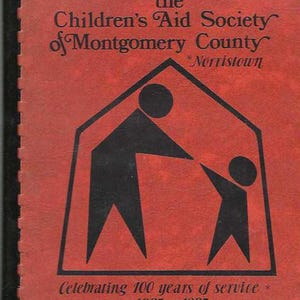 May include: A red booklet with a black silhouette of a house and two figures. The text reads "the Children's Aid Society of Montgomery County *Norristown* Celebrating 100 years of service * 1885-1985".