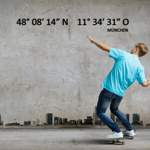 May include: A person on a skateboard in front of a concrete wall with a city skyline in the background. The wall has the coordinates 48&deg; 08&prime; 14" N 11&deg; 34' 31" O and the word M&Uuml;NCHEN written below.