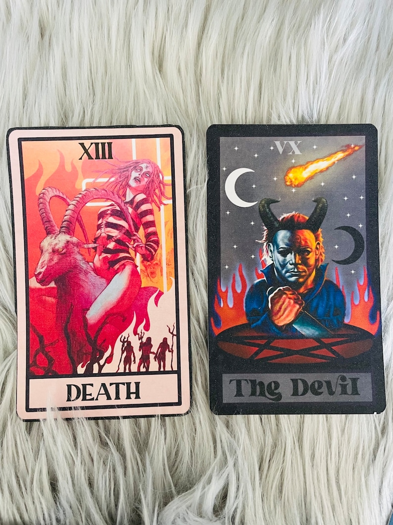 May include: Two tarot cards with dark backgrounds and illustrations. One card features a figure riding a goat with the word "DEATH". The other card depicts a devilish figure with the words "The Devil". Both cards have a black border.