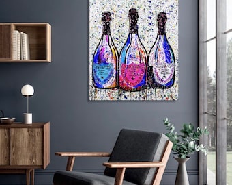 May include: Three champagne bottles with colourful paint splatters on a white background. The bottles are arranged in a row, with the labels facing forward. The labels are in French and feature a gold star.