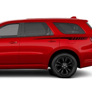 Könnte beinhalten: Ein roter Dodge Durango SUV mit schwarzen Seitenaufklebern. Die Aufkleber befinden sich an den hinteren Türen und haben ein geometrisches Design in Schwarz und Weiß.