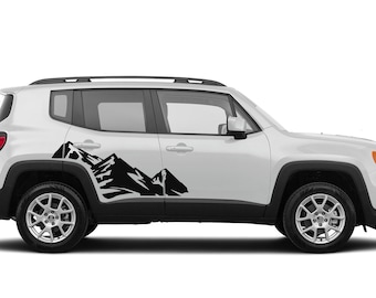 May include: White Jeep Renegade with a black mountain range decal on the side of the vehicle.