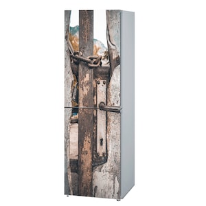 Può includere: Un frigorifero con una porta che presenta una porta in metallo arrugginito con una catena e un lucchetto. La porta è crepata e usurata.