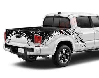 Puede incluir: Camioneta blanca con gráficos negros de salpicaduras de barro en los lados y la puerta trasera. La camioneta tiene un parachoques trasero negro y ruedas negras.