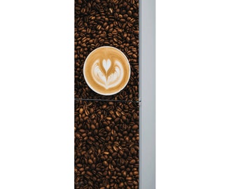 Pode incluir: Um refrigerador de aço inoxidável com um design de grãos de café e arte latte. O refrigerador tem um design de porta dupla com um congelador na parte superior e um refrigerador na parte inferior.