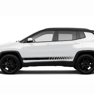 Puede incluir: Un Jeep Compass blanco con rayas laterales negras y llantas negras. El coche se muestra de lado.
