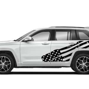 May include: A white SUV with a black and white American flag decal on the side. The decal is a distressed design with stars and stripes.
