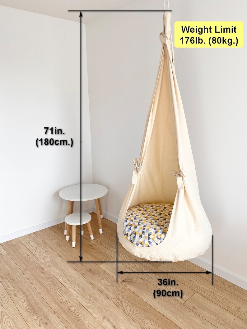 May include: A white fabric hanging chair with a yellow and blue patterned cushion. The chair is suspended from the ceiling and has a weight limit of 176 pounds (80 kilograms). The chair is 71 inches (180 centimeters) tall and 36 inches (90 centimeters) wide.