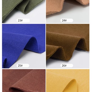 May include: Close-up of six fabric swatches in different colors. The swatches are folded in half and show the texture of the fabric. The colors are: olive green, light brown, royal blue, dark brown, maroon, and yellow.