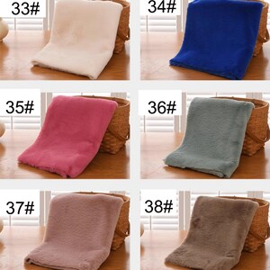 May include: Six different colors of faux fur fabric swatches, labeled with numbers 33, 34, 35, 36, 37, and 38. The swatches are displayed on a wooden surface.