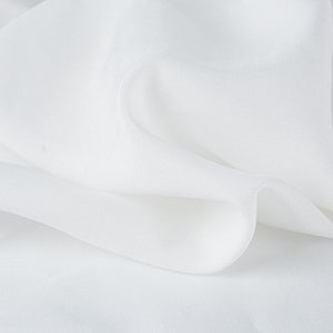 May include: White sheer fabric with a smooth texture and a soft drape.
